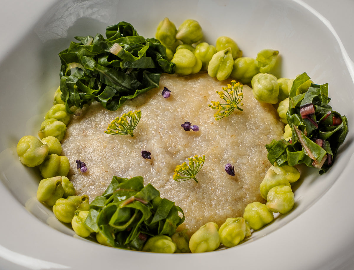 A plated dish with green garnishes served at Mutra restaurant.